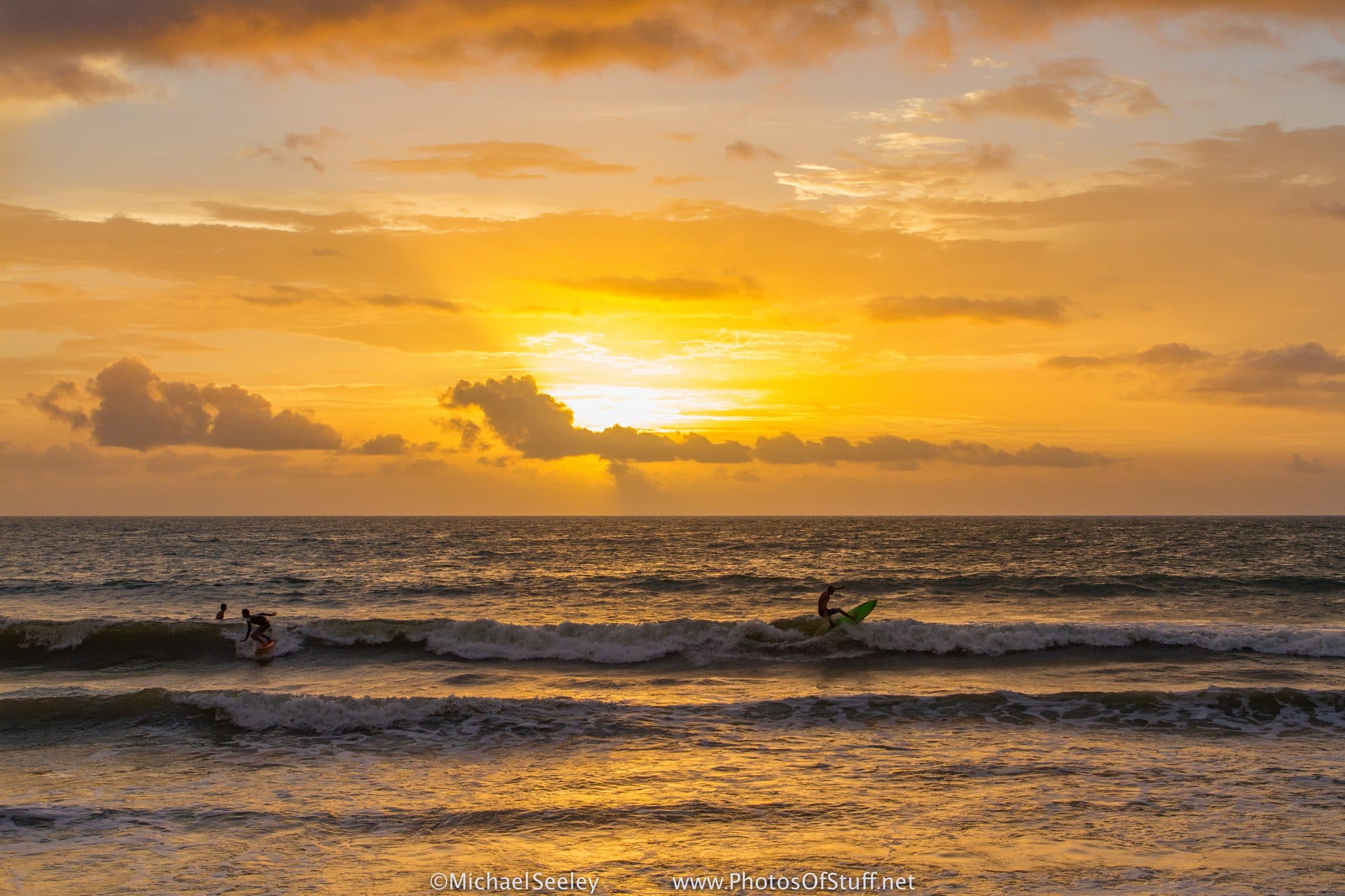 Surfers catching waves at Florida sunrise